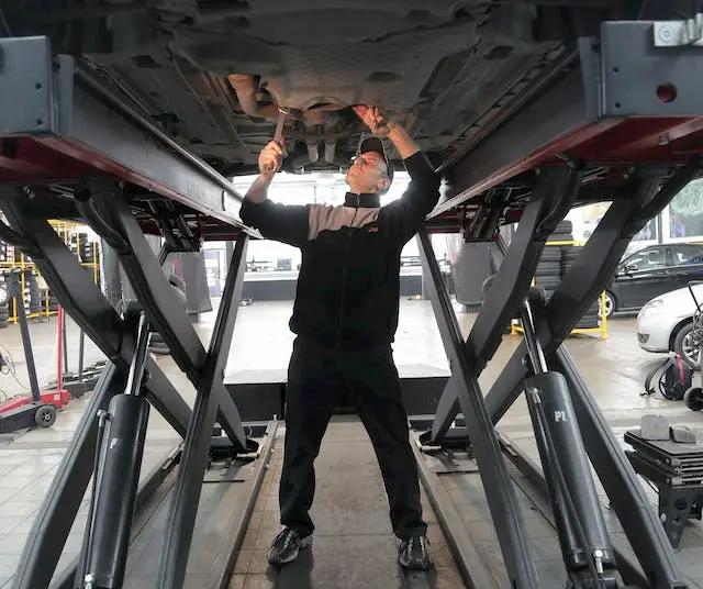 Personal de mantenimiento del coche arreglando un vehículo